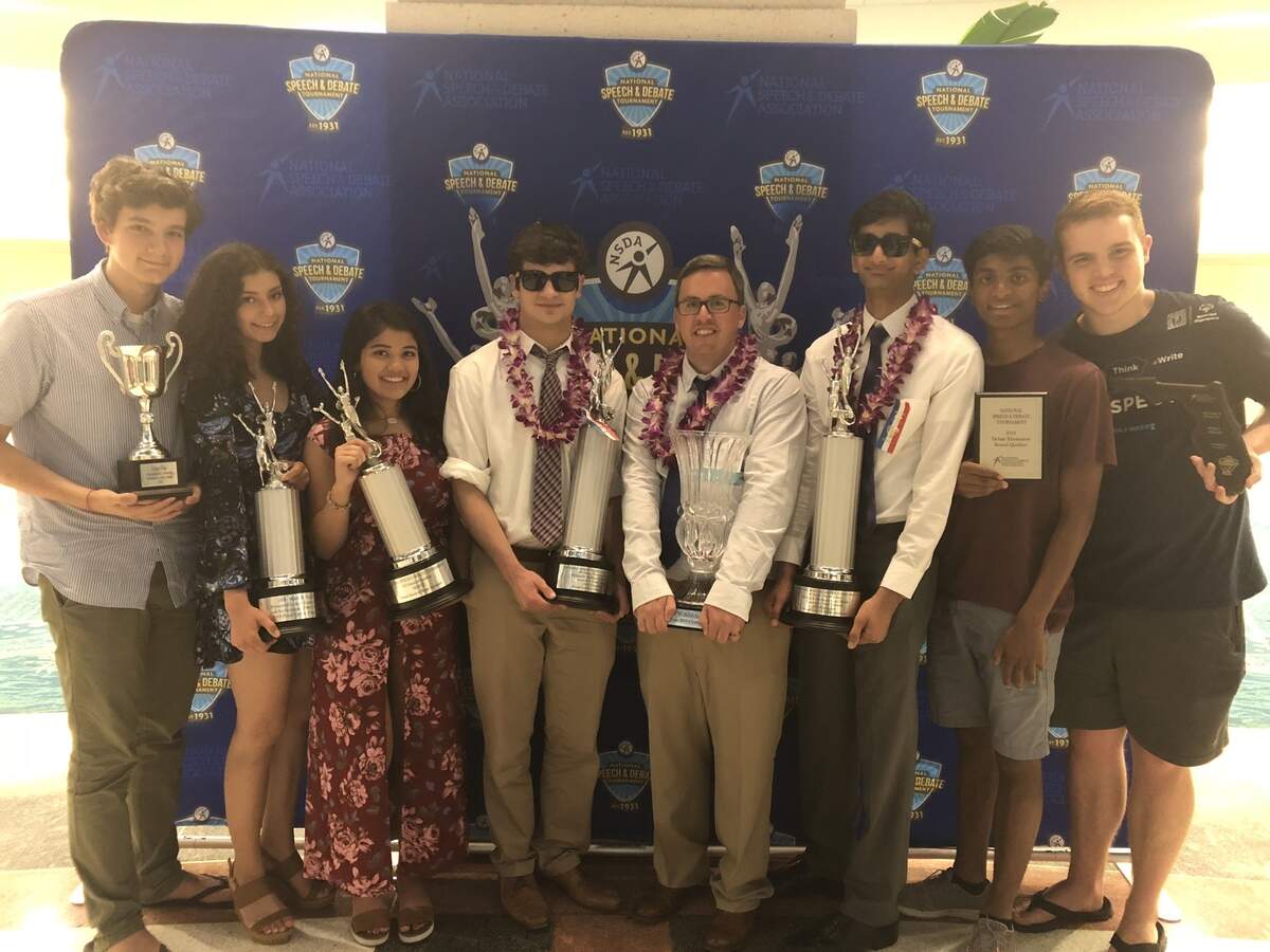 (From left): Students Niko Helixon, Rachel Holzer, Sumaya Hussaini, Stephen Lowe, coach Jared Zuckerman, Danish Khan, Saketh Bhavanasi and Maverick Edwards left the National Speech and Debate Association tournament with lots of hardware.