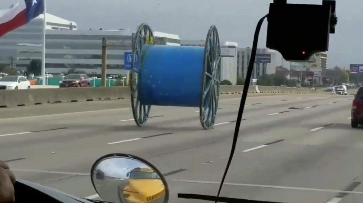For the third time since Oct. 25, a giant industrial spool has fallen off a truck and rolled down a busy Houston highway. Transportation officials say overheight trucks keep hitting overpasses. (ABC 13 screengrab)