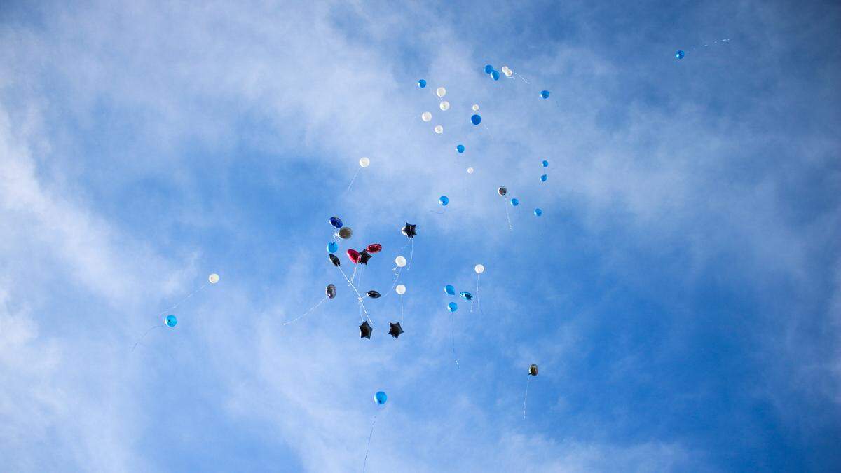 Balloons rise into the sky near a QuikTrip in Raytown on Nov. 23, 2024. Family and friends of Kenneth R. Williams Jr. held a balloon release in honor of his memory after he was shot and killed by a Raytown police officer.