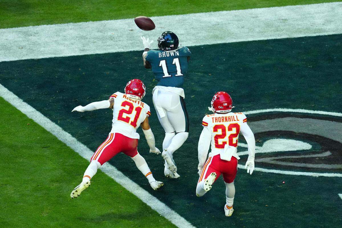 Philadelphia Eagles wide receiver A.J. Brown (11) catches a touchdown pass against Kansas City Chiefs cornerback Trent McDuffie (21) and safety Juan Thornhill (22) during the first half in Super Bowl LVII on Feb. 12, 2023, at State Farm Stadium in Glendale, Arizona.