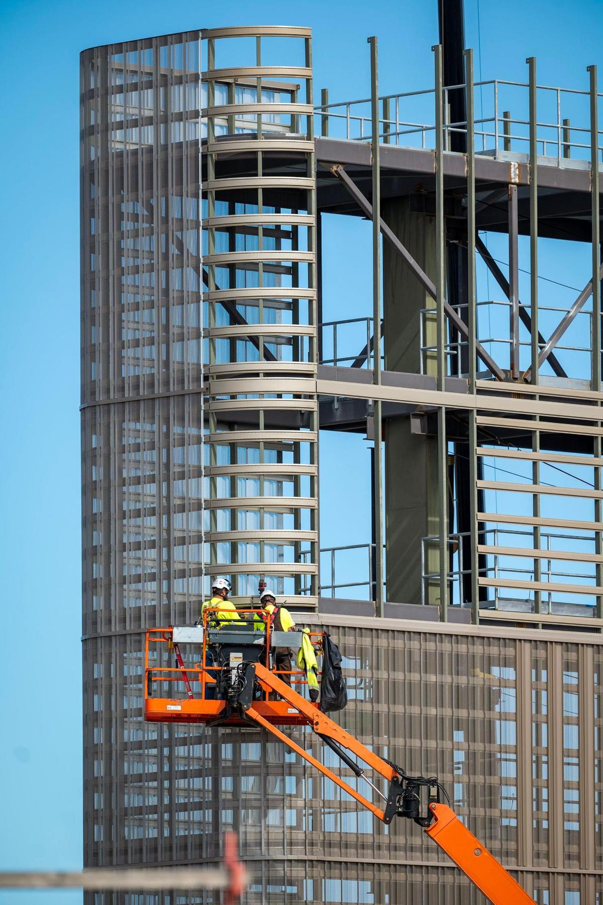 Construction crews use lifts to work on the new scoreboard.