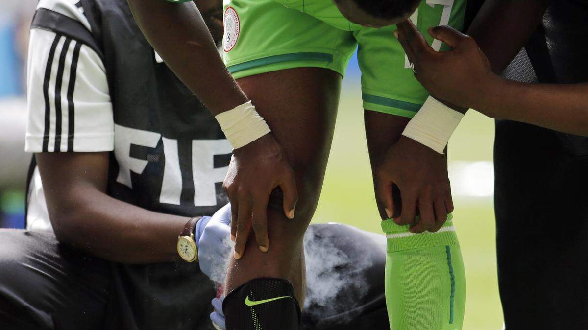 A trainer applies a chilling spray on the back of Nigeria's Ogenyi Onazi's leg during the World Cup round of 16 soccer match between France and Nigeria at the Estadio Nacional in Brasilia, Brazil, Monday, June 30, 2014.