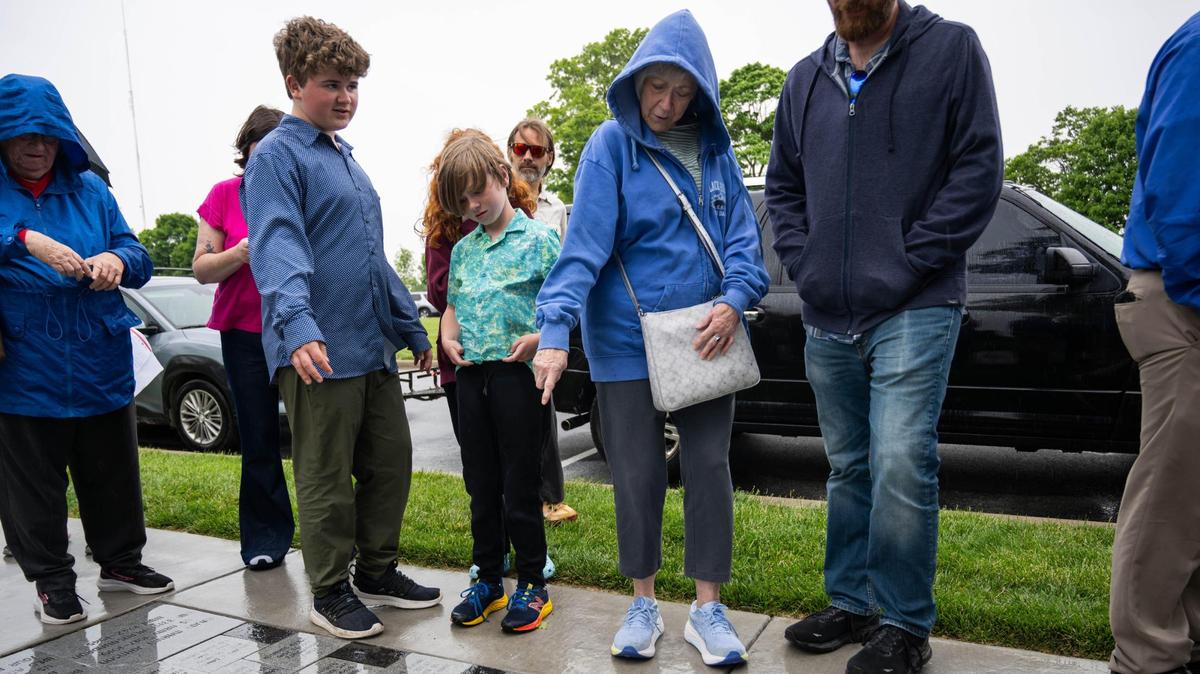Martha Burt and her family search for the brick dedicated to her husband, Gene Burt, following the Walk of Honor Dedication Ceremony at the WWI Museum and Memorial on Monday, May 26, 2025. Gene Burt was a longtime museum and memorial volunteer.