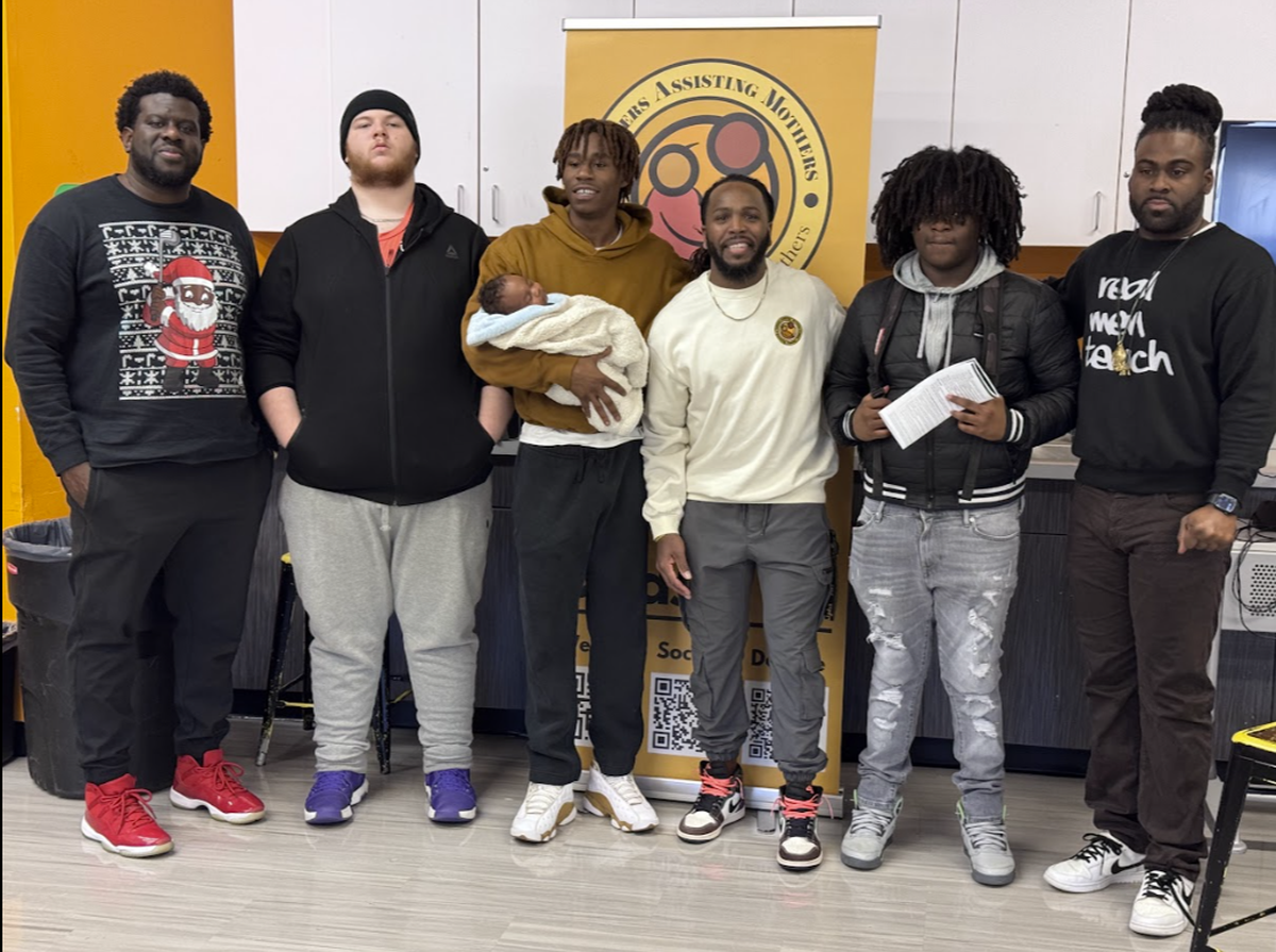 James Hogue (center right) pictured after a session with a cohort from Fathers Assisting Mothers, a nonprofit teaching service dedicated to preparing expectant fathers and non-birthing partners through education and support to become active participants in the childbirth experience
