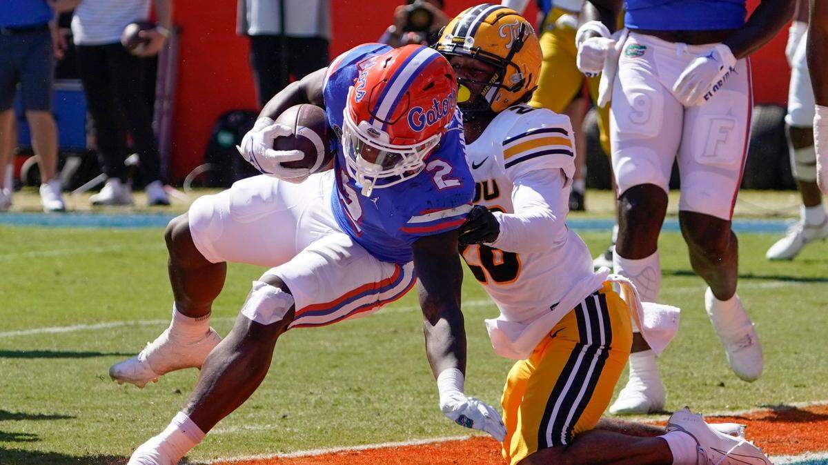 Florida running back Montrell Johnson Jr., left, gets past Missouri defensive back Joseph Charleston for a touchdown on a 3-yard run Saturday in Gainesville, Fla.