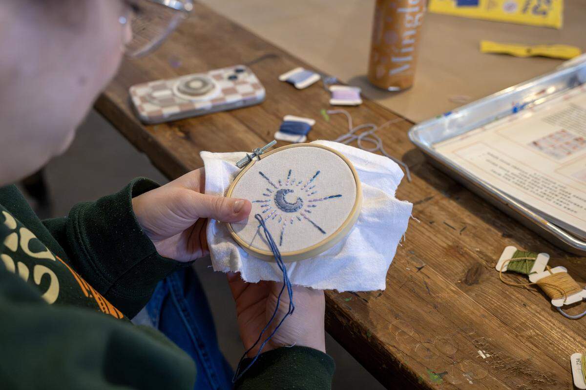 A guest stitches an embroidery design at ADHDIY Craft Cafe on Saturday, Feb. 7, 2026, in Kansas City,