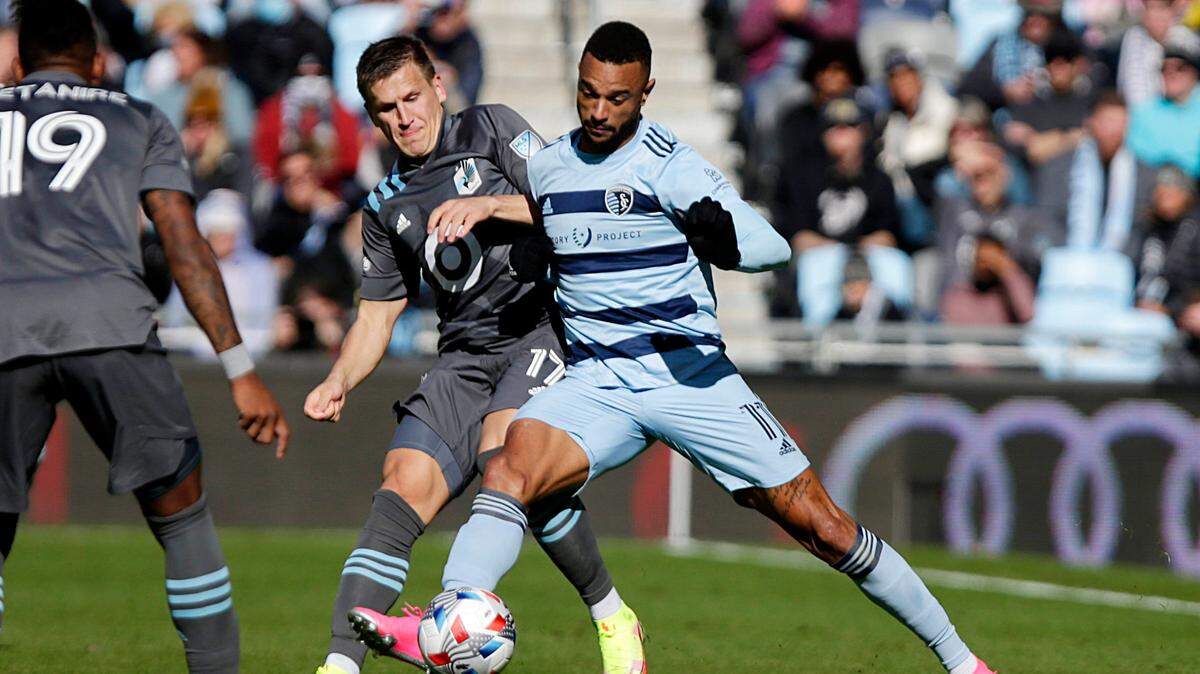 Minnesota United midfielder Robin Lod and Sporting Kansas City forward Khiry Shelton, right, mix it up during Sunday’s match in St. Paul, Minn.