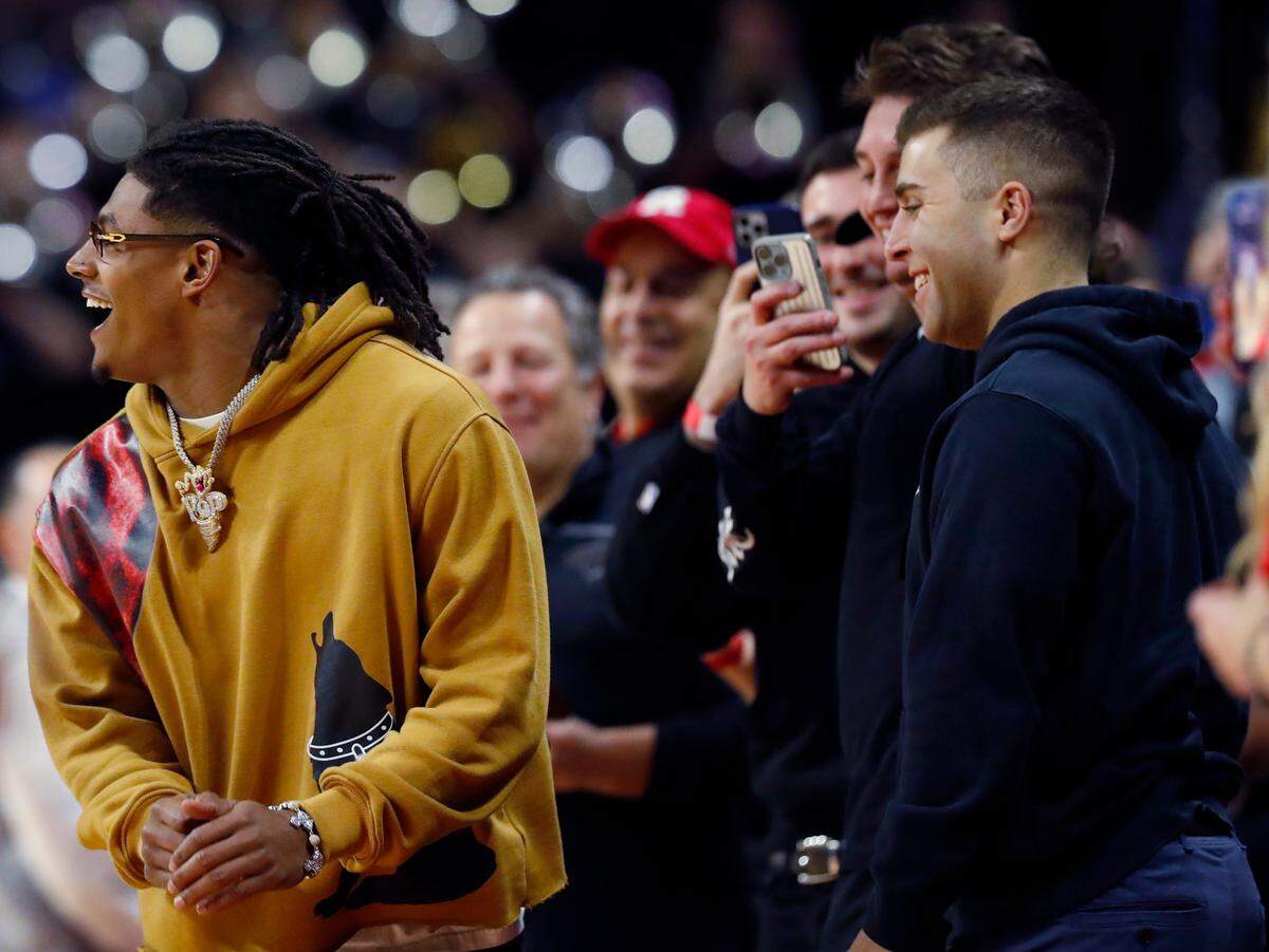 Kansas City Chiefs running back Isiah Pacheco, left, watches during the first half of an NCAA college basketball game between Rutgers and Michigan in Piscataway, N.J., Thursday, Feb. 23, 2023. (AP Photo/Noah K. Murray)