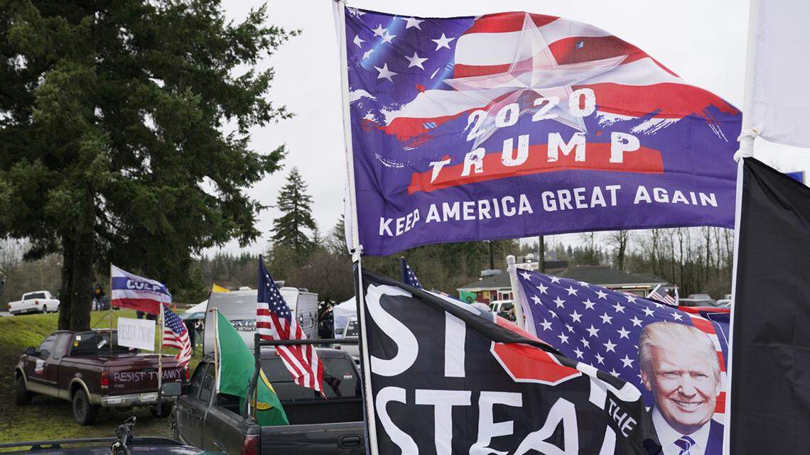 FILE - Flags supporting President Donald Trump and one that reads “Stop the Steal” are displayed during a protest rally, Jan. 4, 2021, at the Farm Boy Drive-In restaurant near Olympia, Wash. A review by The Associated Press in the six battleground states disputed by former President Trump has found fewer than 475 cases of potential voter fraud, a minuscule number that would have made no difference in the 2020 presidential election. Democrat Joe Biden won Arizona, Georgia, Michigan, Nevada, Pennsylvania and Wisconsin and their 79 Electoral College votes by a combined 311,257 votes out of 25.5 million ballots cast for president. (AP Photo/Ted S. Warren, file)