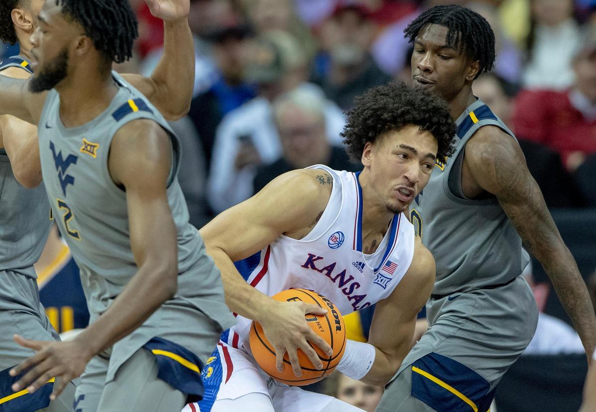 Kansas forward Jalen Wilson (10) controls the ball around West Virginia defenders during an NCAA college basketball game in the second round of the Big 12 Conference tournament Thursday, March 9, 2023, in Kansas City.