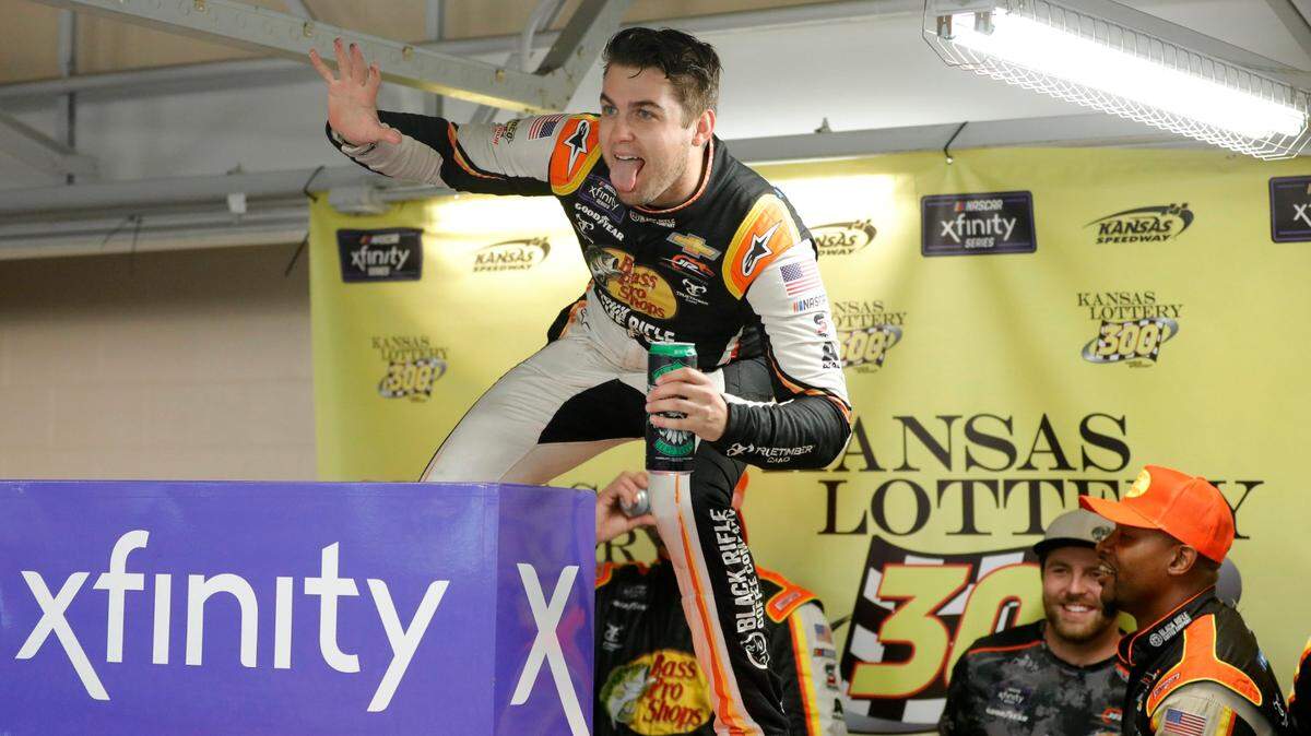 NASCAR driver Noah Gragson celebrates his win atop his racecar in a Kansas Speedway garage area after winning Saturday’s Xfinity Series race. The race was called after 93 laps due to rain. 