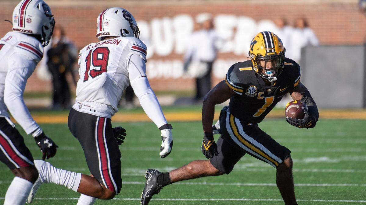 Missouri running back Tyler Badie, right, runs past South Carolina linebacker Brad Johnson, center during the first quarter of an NCAA college football game Saturday, Nov. 13, 2021, in Columbia, Mo. (AP Photo/L.G. Patterson)