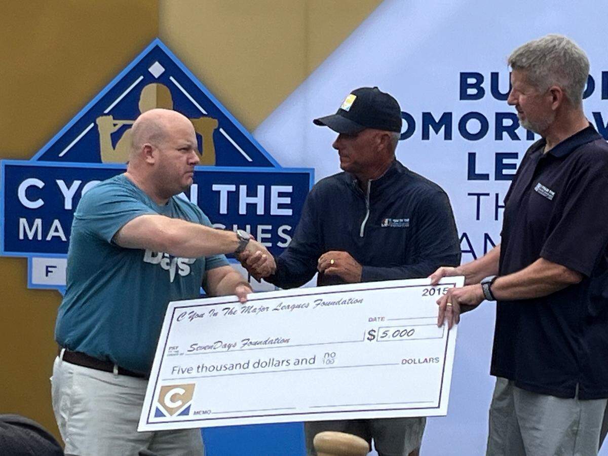 Former Royals executive Dayton Moore (center) presents a check to Tony Corporon of the SevenDays foundation. Corporon’s father and nephew were shooting victims at the Jewish Community Center in 2014. Also pictured, Matt Fulks from the C You in the Major Leagues Foundation
