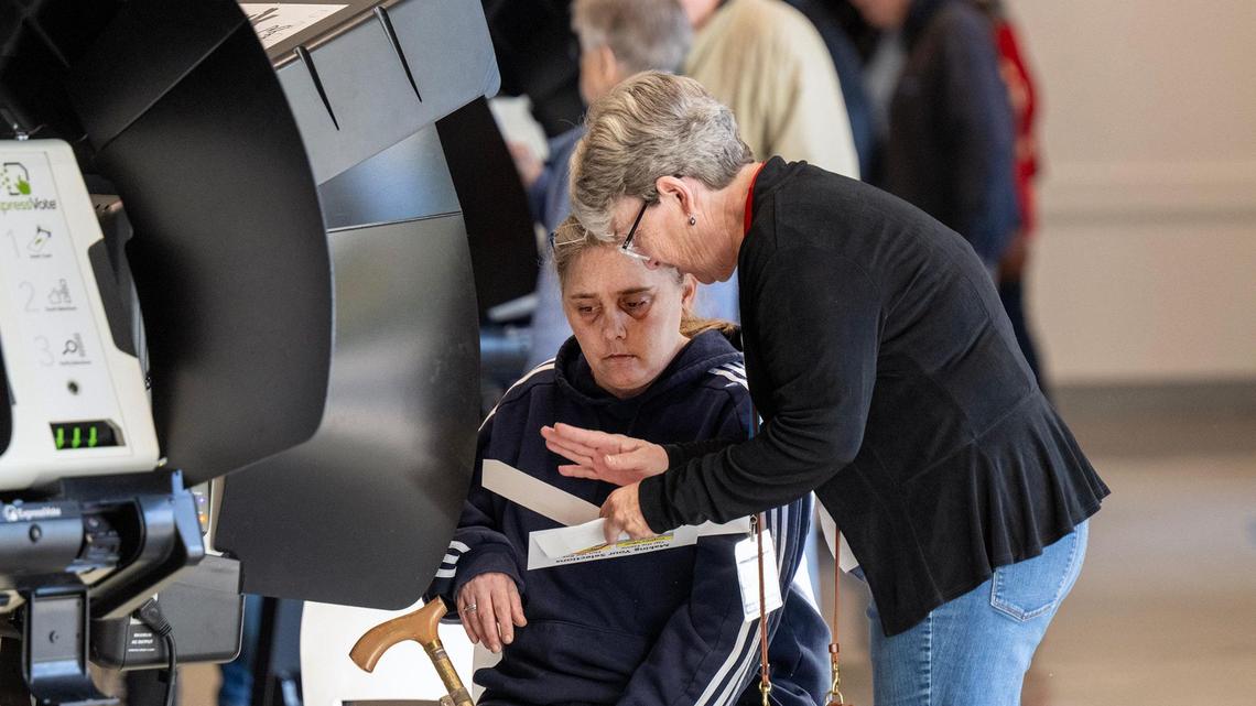 An election worker, right, assisted a Johnson County resident during the first day of in-person advance voting for the 2024 General Election at The Arts and Heritage Center on Saturday, October 19, 2024, in Overland Park.