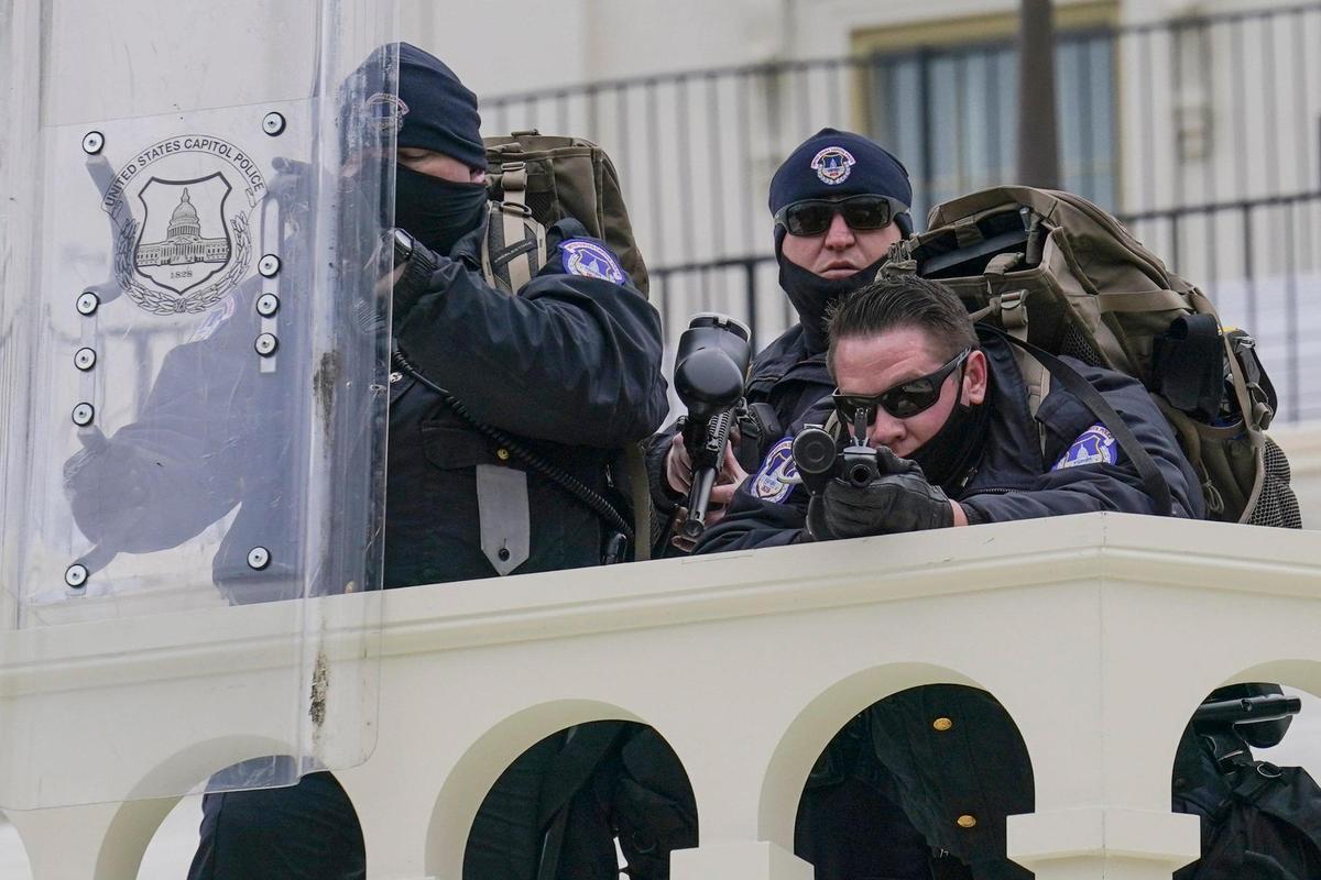Police keep a watch on demonstrators who tried to break through a police barrier, Wednesday, Jan. 6, 2021, at the Capitol in Washington. As Congress prepares to affirm President-elect Joe Biden’s victory, thousands of people have gathered to show their support for President Donald Trump and his claims of election fraud.(AP Photo/John Minchillo)