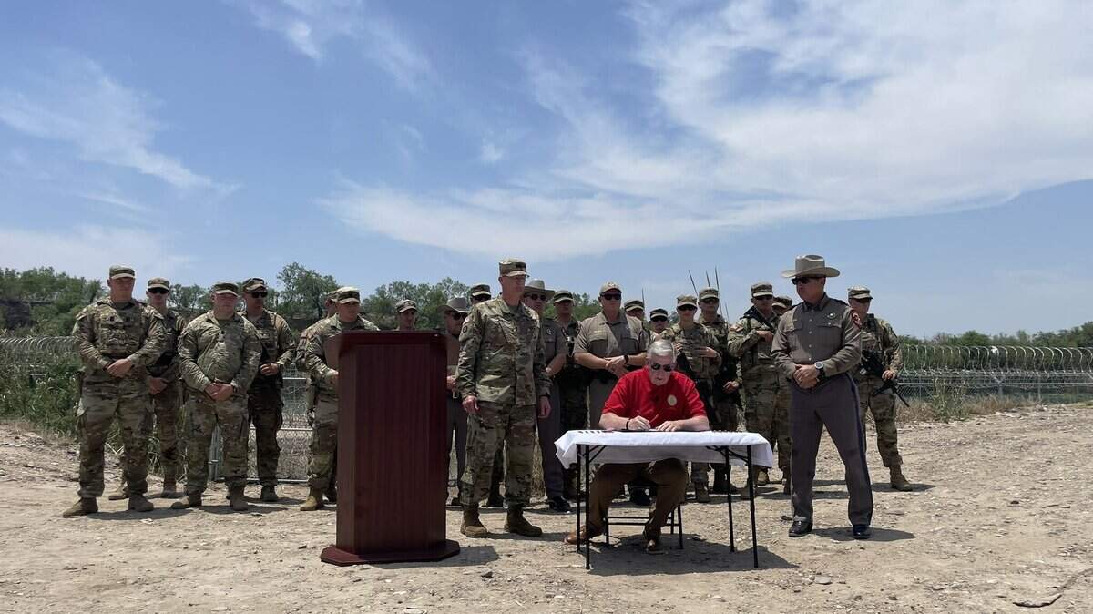 Missouri Gov. Mike Parson, at a news conference in Texas on May 8, 2024, signs a supplemental budget to fund the deployment of Missouri troops to help Texas’ border operations.