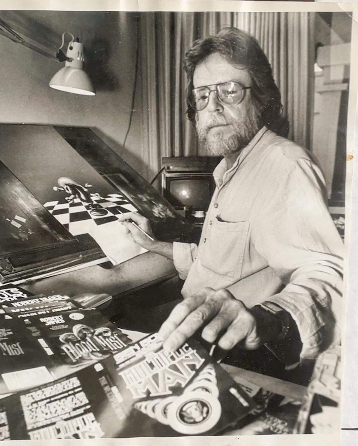 A photograph of David Mann creating artwork, at The David Mann Chopper Fest in Kansas City, on Saturday, Sep. 20, 2025. Mann, born in Kansas City, attended the Kansas City Art Institute in the 60s before answering an ad for an illustrator in Easyrider Magazine. He created art for the magazine for 30 years.
