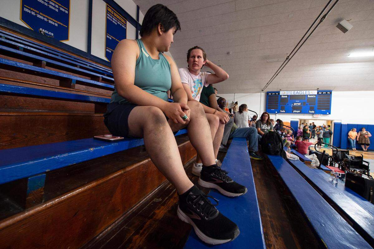 Anna Le, Wichita, left, a passenger on the Amtrak train that crashed near Mendon, Missouri, talks to Alex Grieve while they sit in the stands of the gymnasium at Northwestern R-1 School where several passengers took shelter Monday after the crash. Le’s hands and knees were dirtied while crawling through the hallways of the overturned train to escape the wreckage.