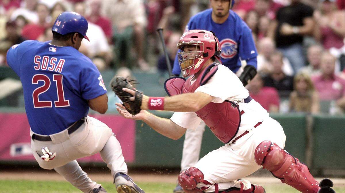 St. Louis Cardinals catcher Mike Matheny, right, reaches to make the tag on Chicago Cubs’ Sammy Sosa (21) during the second inning in St. Louis, Thursday, June 24, 2004. Sosa tried to score from second on a single to center field by Corey Patterson. (AP Photo/Bill Boyce)