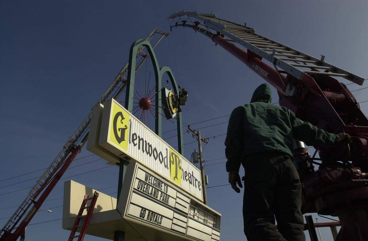 Suspended from a crane, Dave Brunner of the Acme Sign Co. cuts through a metal support on the ‘G’ in the soon-to-be razed Glenwood Theatre, in 2000. The ‘G’ and other parts of the sign were purchased by The Fine Arts Theatre Group.