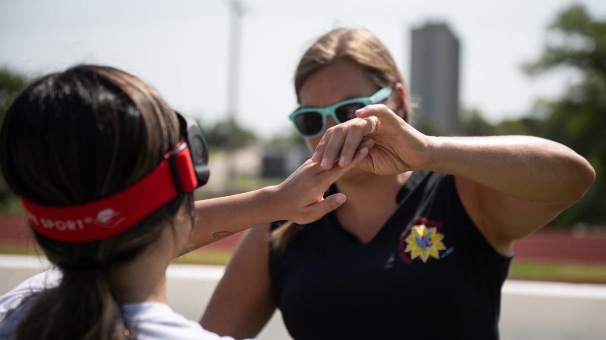 Leah Enright, the Kansas State School for the Blind’s blind sports coordinator, teaches blind soccer basics to KC Star intern Kylie Volavongsa at KSSB’s blind soccer field on Thursday, August 1, 2024, in Kansas City, Kansas