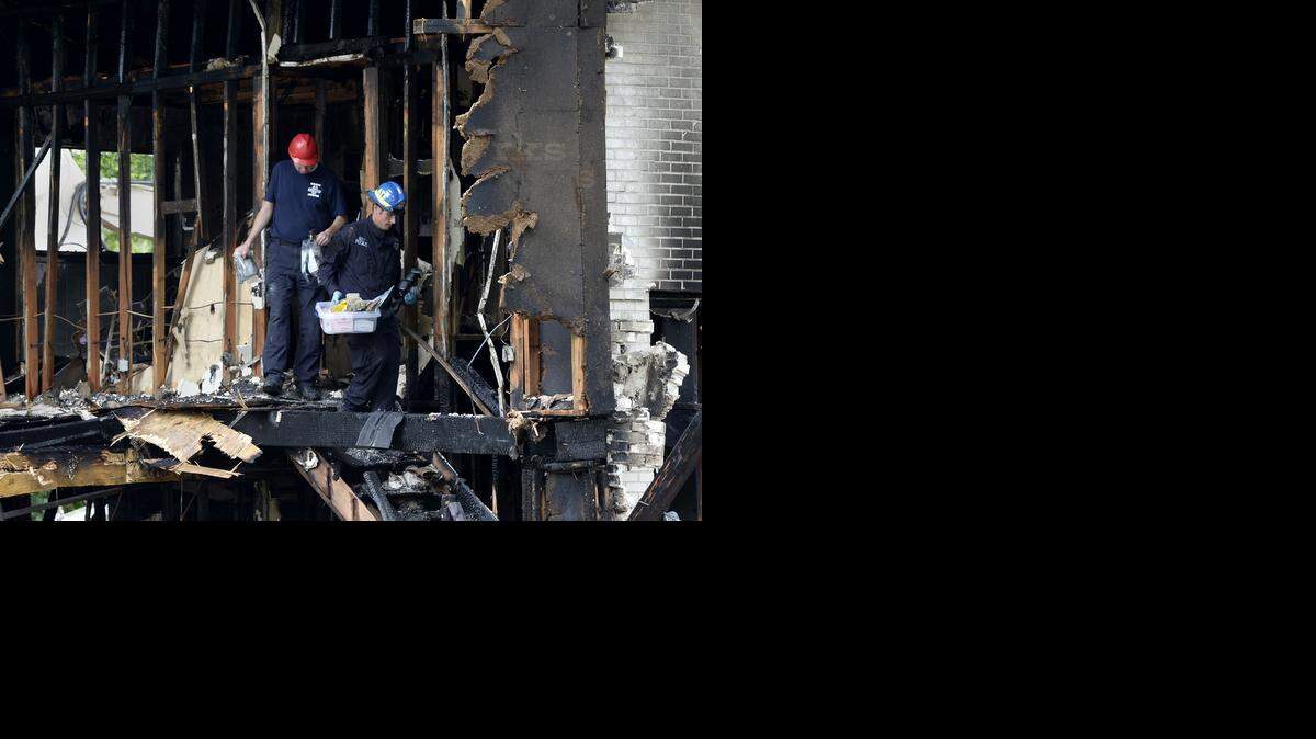 
A Kansas City Police Dept. bomb and arson investigator (left) and one from the federal Bureau of Alcohol, Tobacco and Firearms looked Friday morning for the cause of a Wednesday night's explosion and fire at a home in the 9100 block of Tennessee Avenue in southeast Kansas City. Part of the home was demolished Friday so the investigators could safely do their work.
