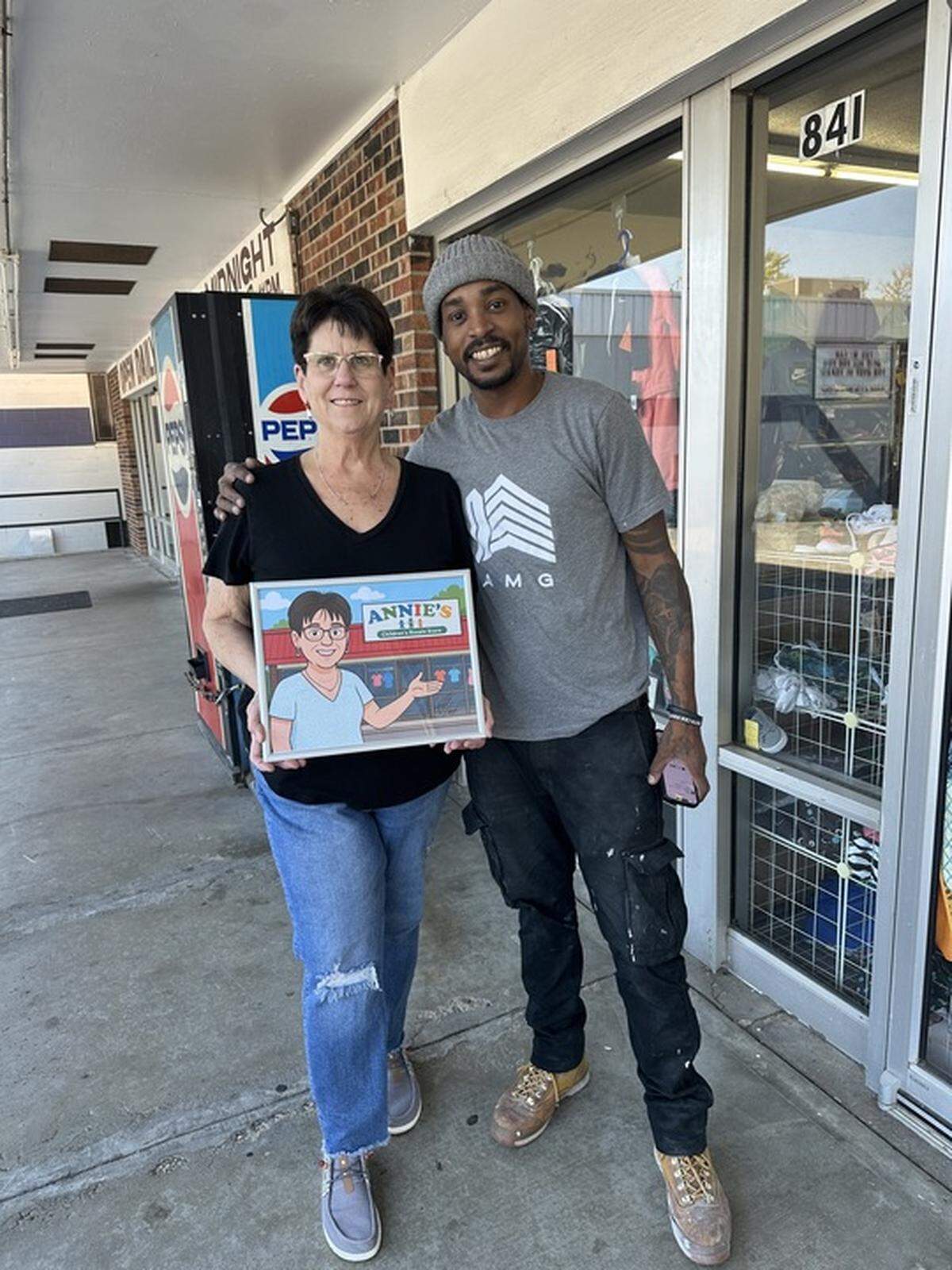 Ann “Annie” Michael poses with customer Drew Easley, who created an artpiece as a parting gift.