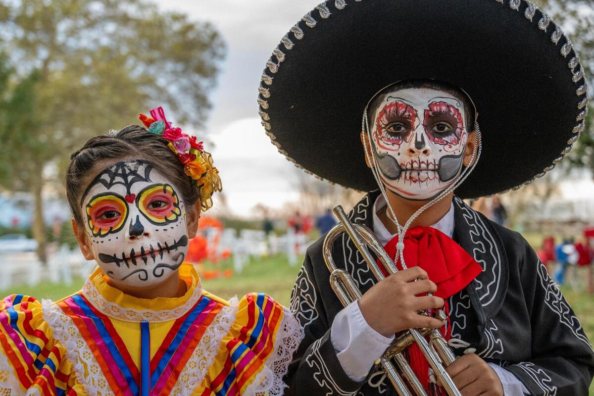 Eight-year-old Mia Murguia, left, and her 10-year-old brother Marcos Murguia dress as a Catrina and Catrino during the Dia de los Muertos festival at the Mattie Rhodes Center.