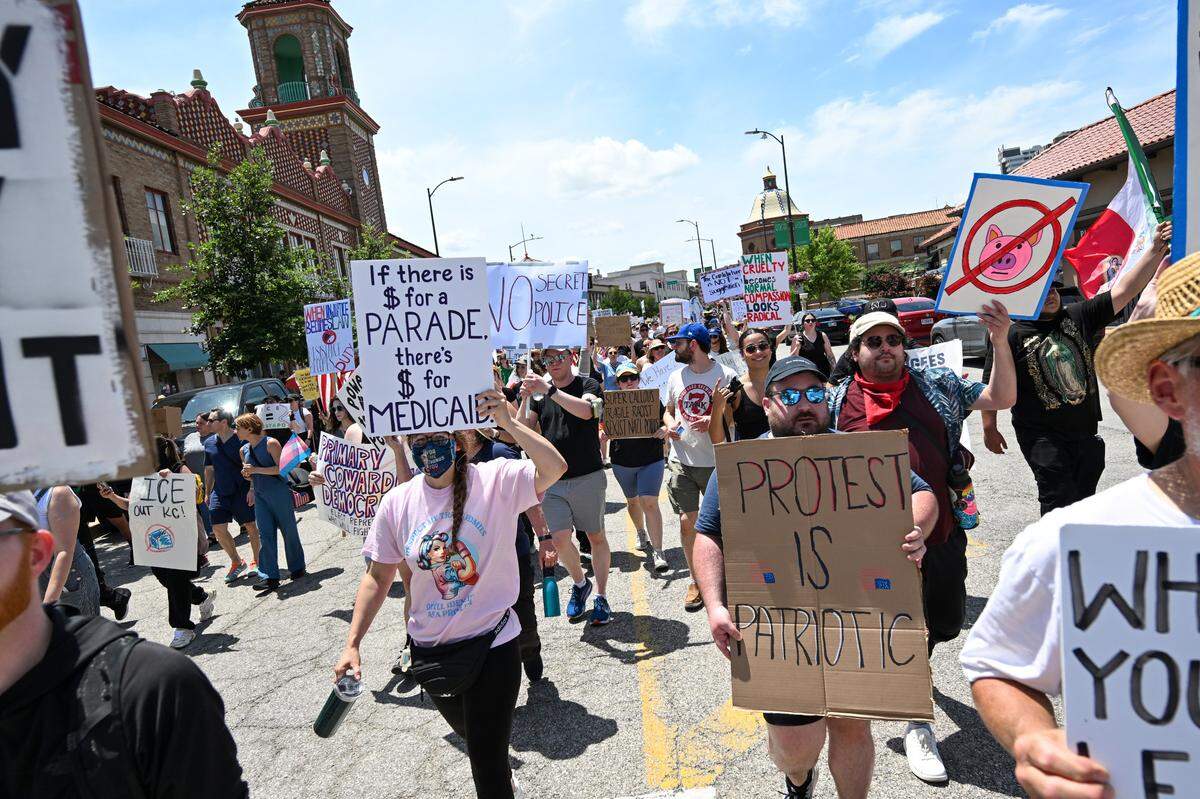 Demonstrators march through the streets in the Country Club Plaza during the “No Kings” rally Saturday, June 14, 2025, in Kansas City.
