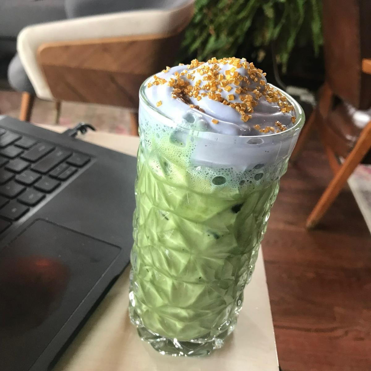 A lavender matcha latte with lavender whipped cream and golden sugar sprinkles from PH Coffee in the Pendleton Heights neighborhood of Kansas City