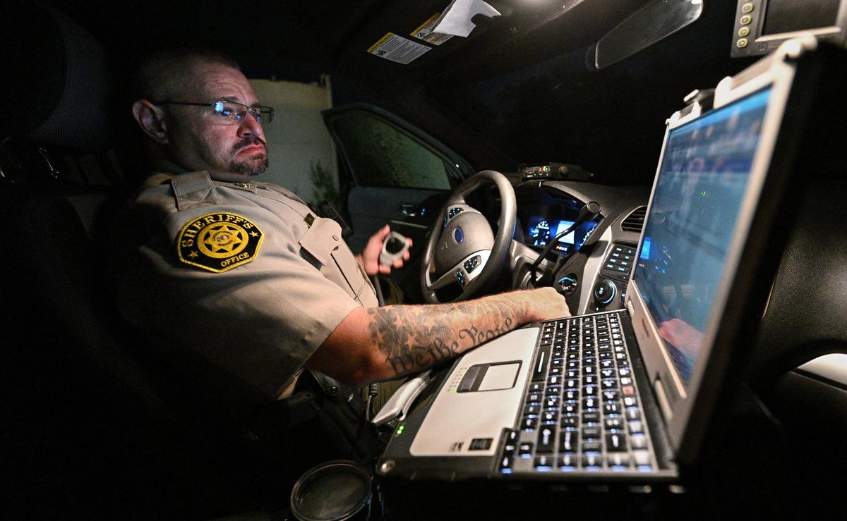 Camden County Deputy Darrin Skinner checked his computer while on patrol this month at the Lake of the Ozarks. The lake has drawn wide attention and record crowds since spurning pandemic restrictions in the spring of 2020. But the growth has also brought more crime.
