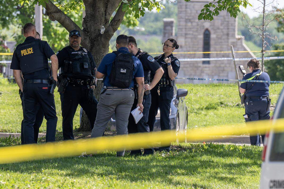 Kansas City police officers gather near a taped-off area following a reported shooting near the Tony Aguirre Community Center on Sunday, May 3, 2026, in Kansas City.