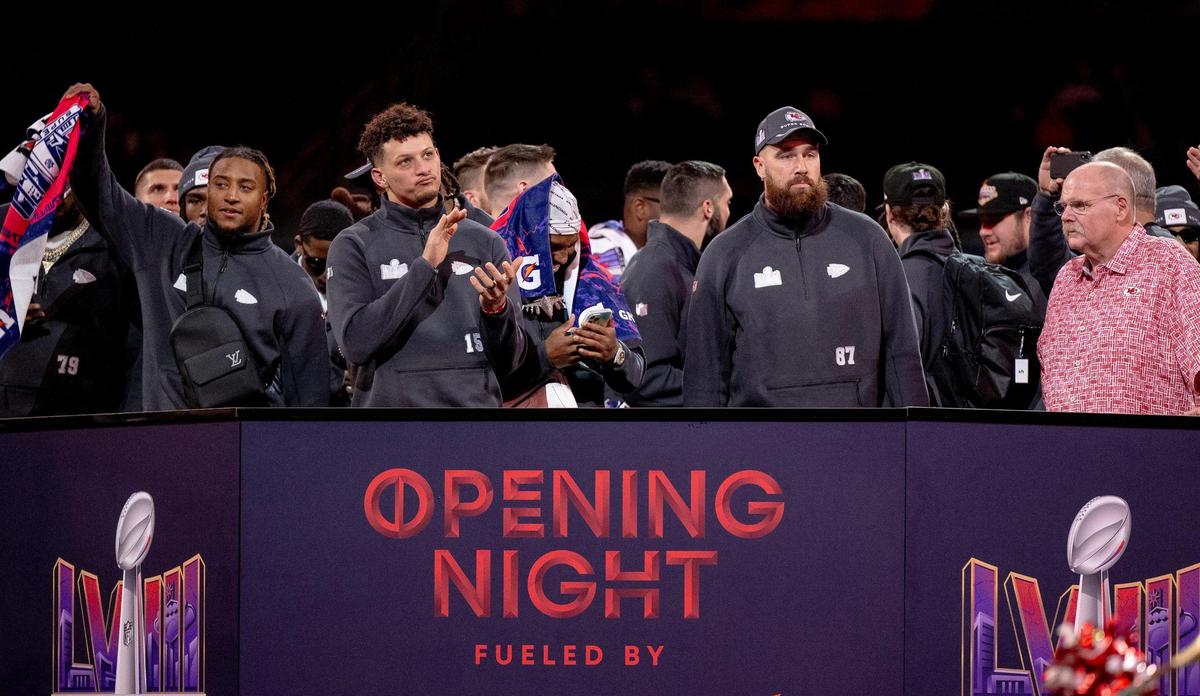 Kansas City Chiefs safety Justin Reid, left, waves a towel as quarterback Patrick Mahomes, tight end Travis Kelce and coach Andy Reid stand on stage during Super Bowl LVIII’s Opening Night event at Allegiant Stadium on Monday, Feb. 5, 2024, in Las Vegas.