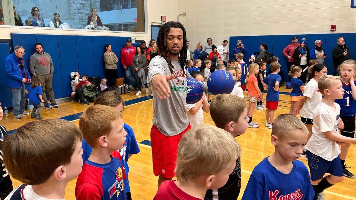 Kansas backup point guard Bobby Pettiford instructs young attendees at the Jayhawks’ annual holiday clinic Wednesday, held at the practice facility.