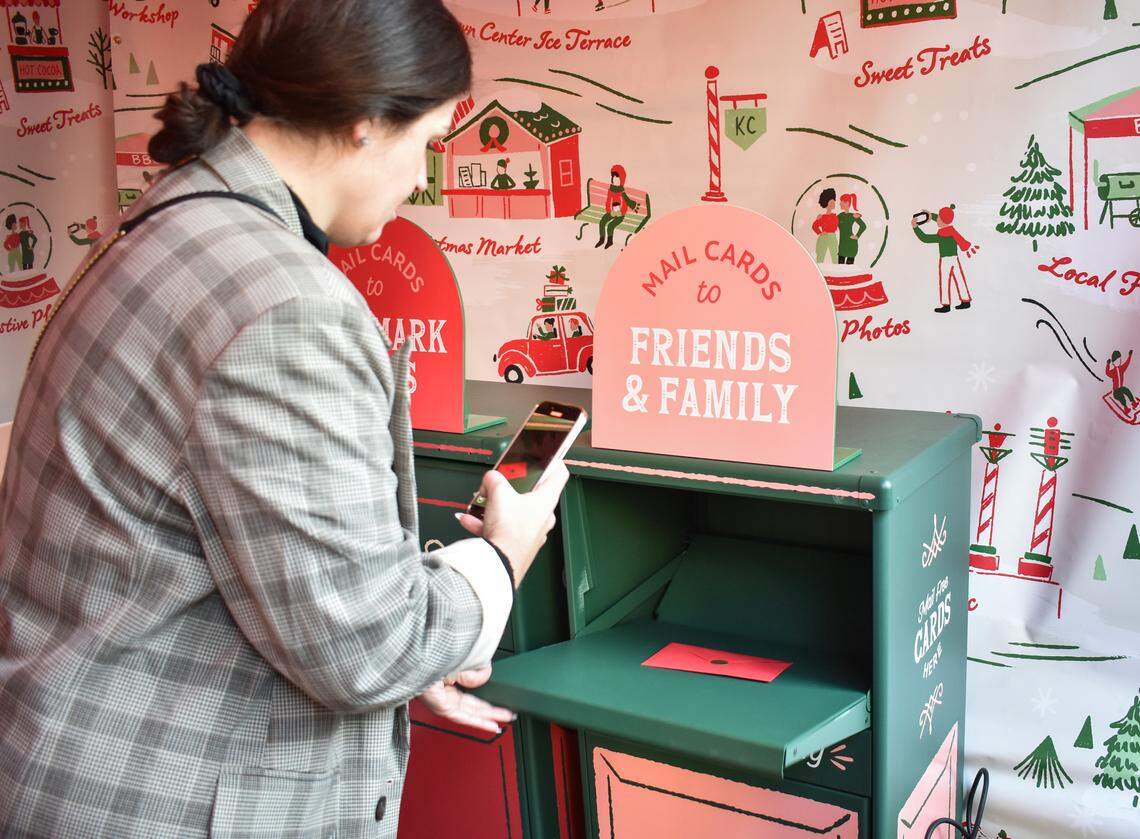 A radio host from 90.9 The Bridge mails a letter to loved ones at the card-sending station inside the free Hallmark Christmas Experience. All the letters are stamped and sent for free.