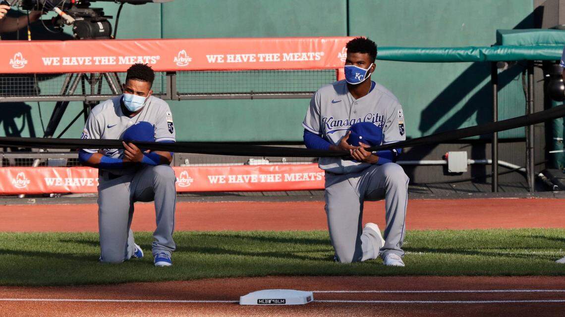 Kansas City’s Erick Mejia, left, and Franchy Cordero showed their support for social justice on opening day as they took a knee and held a black ribbon before the Royals played in Cleveland.
