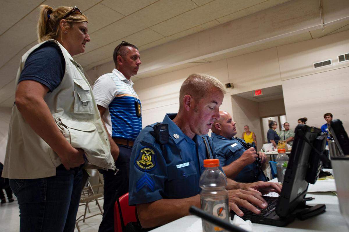 Late in the afternoon Officer Borgmeyer and other first responders work to compile a list of people who came through Northwestern R-1 School as passengers from the train gather in the gymnasium after an Amtrak train derailed on Monday, June 27, 2022, near Mendon, MO.