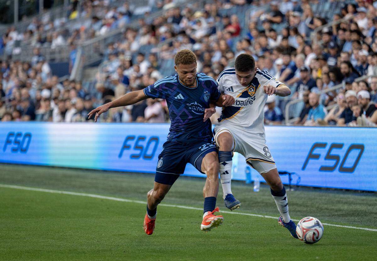 Sporting Kansas City defender Zorhan Bassong (22) battles LA Galaxy midfielder Lucas Sanabria (8) for the ball in the first half at Sporting Park on Wednesday, May 13, 2026, 2026, in Kansas City, Kansas,