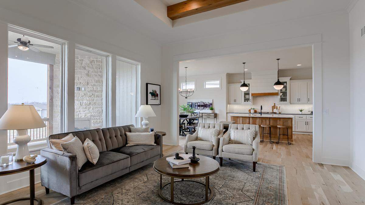 The open kitchen, dining and great rooms, plus master bedroom, den, and laundry room are all on the main level in the story and a half Landon II plan at Covington Creek.