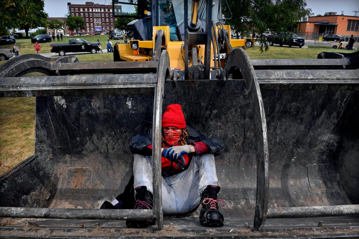 In an act of defiance, Joey Taylor climbed into the scoop of a front loader that the Kansas City Parks & Recreation Dept., drove into the park in order to help clear the homeless camp where Taylor and about two dozen others were living. .