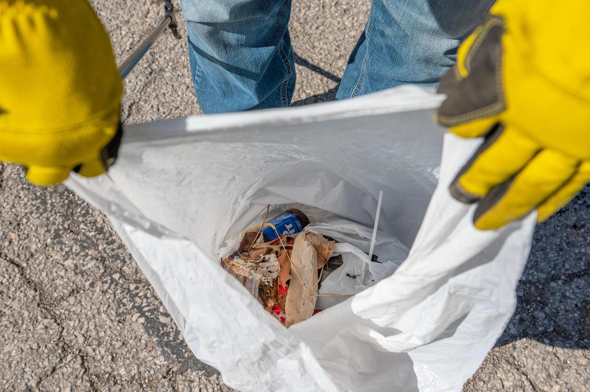 Chris Morales shows a bag filled with debris that he picked up around his Indian Mound neighborhood on Tuesday, April 11, 2023, in Kansas City. Morales regularly picks up litter in the area, either by himself or with other neighbors.