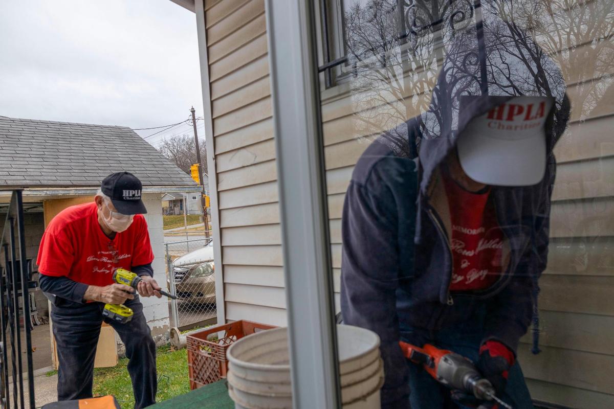 Robert Flores, left, and volunteer Fran Arnett work on repair for a resident on Friday, Dec. 17, 2021, in Kansas City, Kansas. Wyandotte County - where Flores spends most of his time working - is among the poorest counties in Kansas. 