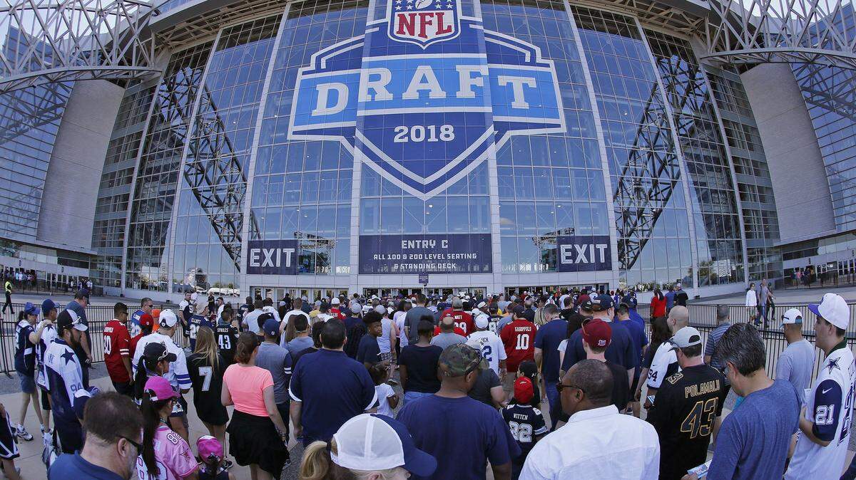 People wait to get into the stadium for the second round of the NFL football draft in Arlington, Texas, Friday.