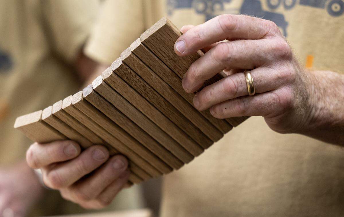 Jay Morris of JHM Woodworks examines a tambour door that will be installed on one of the 115 handmade trucks he and his volunteers are creating for the Toys for Tots program. In addition to the wheels, Morris explained that every truck should have a moving part, so the tambour door is designed to slide up and down.