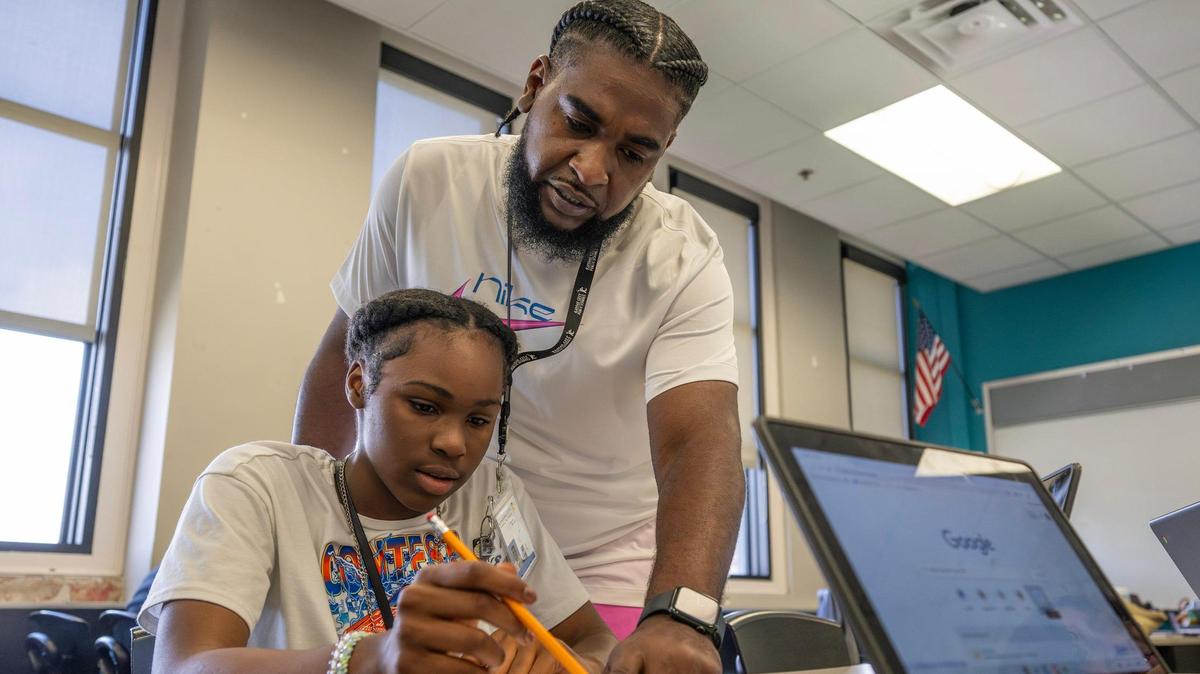 Vincent Gunnels helps a student with their assignment during summer school at Central Middle on Monday, June 16, 2025. Gunnels, a Kansas City Public School 2025 Teacher of the Year, says because he grew up in the same neighborhoods where his students live they can connect in a special way.  