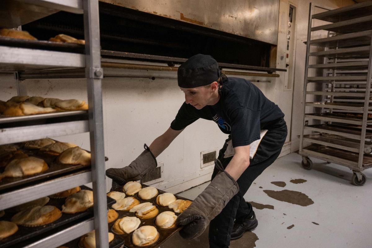 Erin Rodda, a baker at Scratch KC, pulls freshly baked pumpkin cheesecake muffins out of the oven. The finished product will cool and then be packaged for delivery to one of over 200 coffee shops around the metro area.