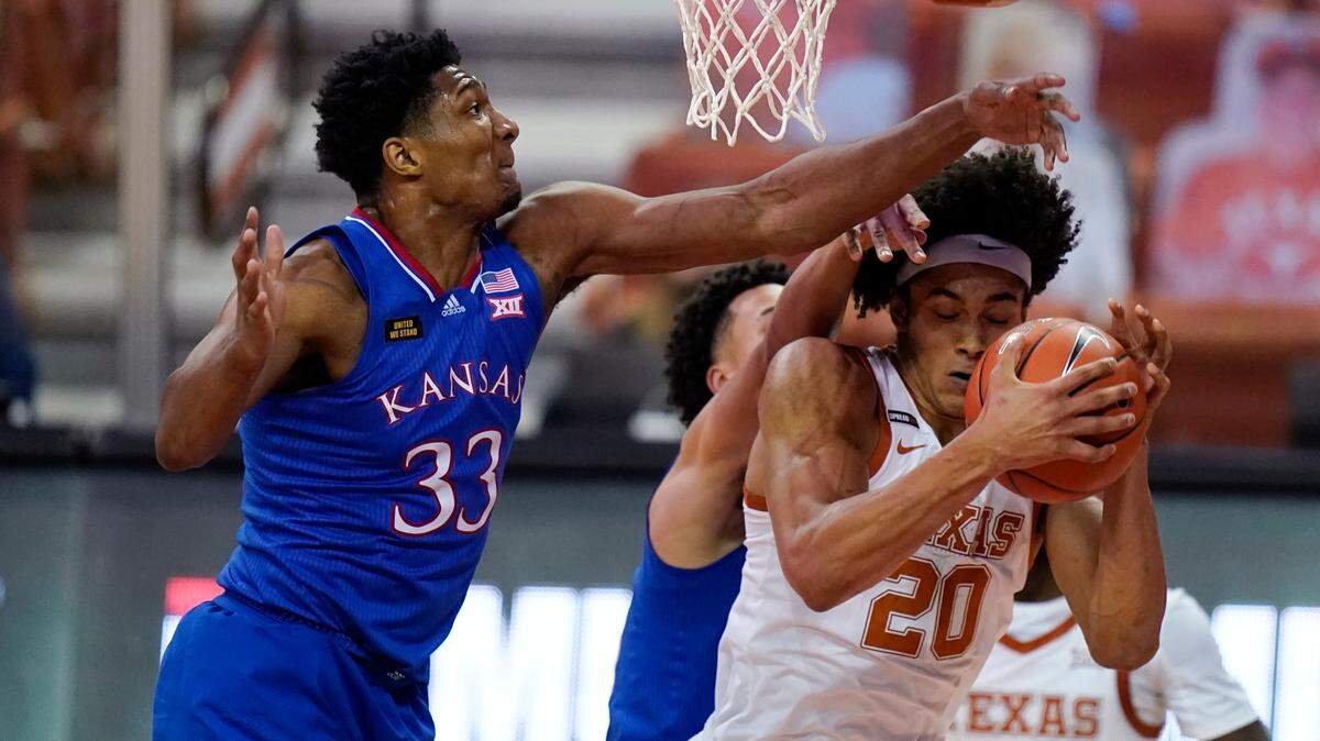 Texas forward Jericho Sims (20) fights for a rebound with Kansas forward David McCormack (33) during the second half of an NCAA college basketball game, Tuesday, Feb. 23, 2021, in Austin, Texas. (AP Photo/Eric Gay)