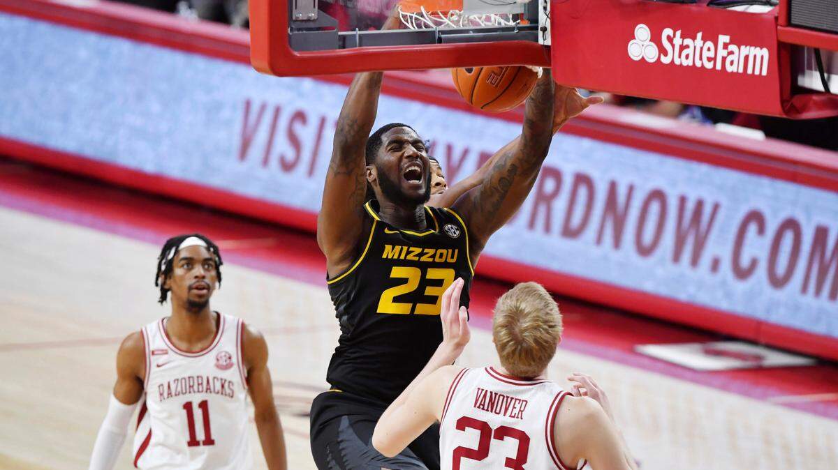 Missouri forward Jeremiah Tilmon (23) dunks the ball over Arkansas defenders Jalen Tate (11) and Connor Vanover (23) during the first half of an NCAA college basketball game in Fayetteville, Ark. Saturday, Jan. 2, 2021. (AP Photo/Michael Woods)