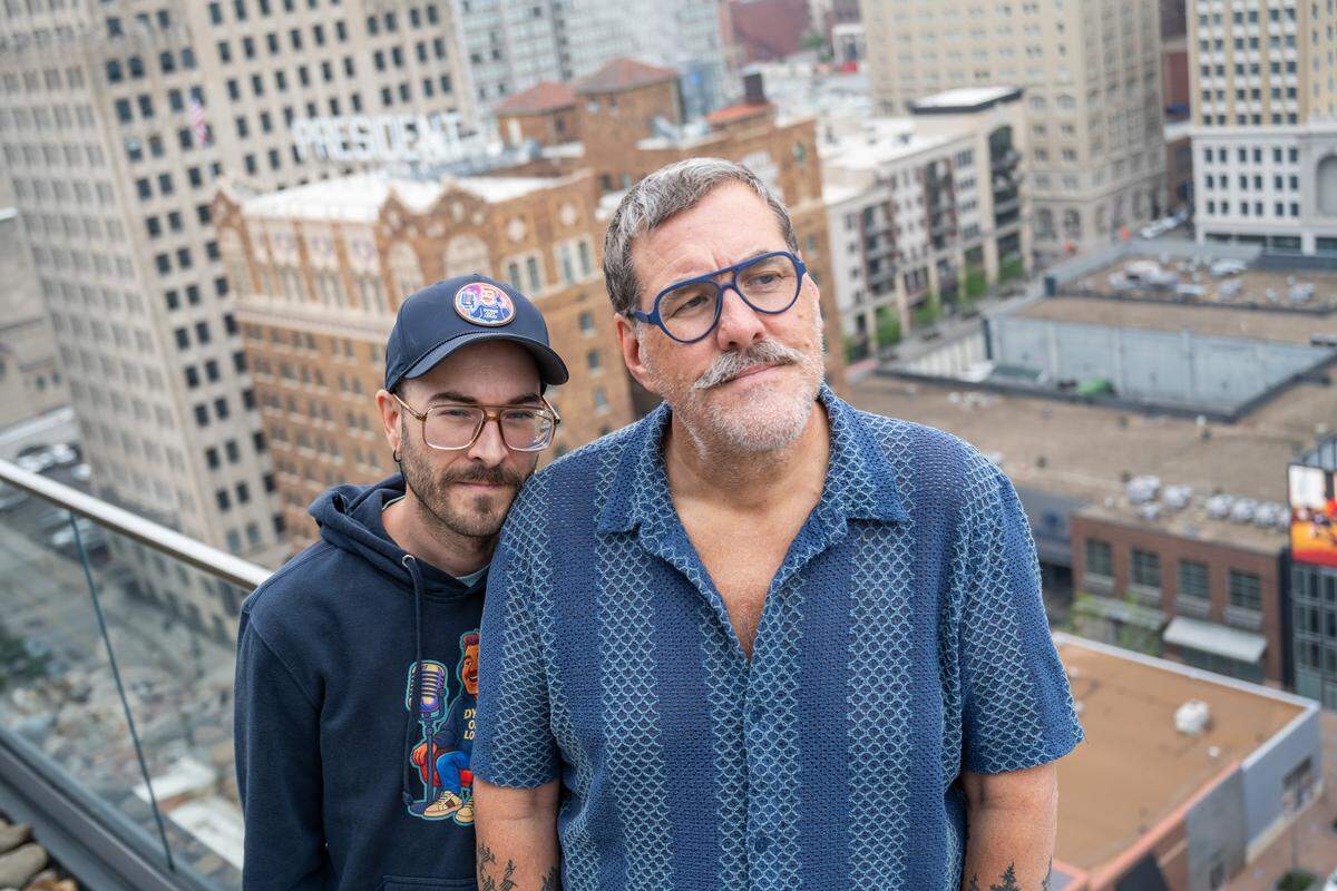 Kris Saim with his husband, Anthony, outside their home on Friday, April 10, in Kansas City. Saim has Stage 4 terminal cancer and is recording a podcast, Dying Out Loud, that talks about death. Saim's husband helped spur the idea of recording about the subject, and is also a producer on the podcast.