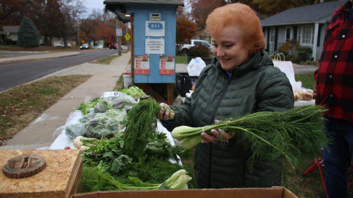 At Tiny Pantry Times, Jennifer Parker lays out fresh produce donations from vendors at the Overland Park Farmers Market.